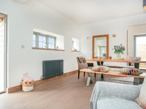 a living room with a table and a chair at Old Highwood - Hog End in Luppitt