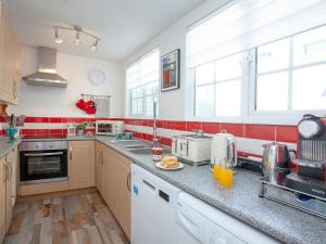 Una cocina con paredes y ventanas rojas y blancas. en Beachside, en Teignmouth