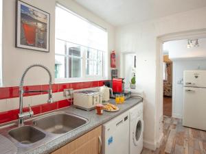 una cocina con fregadero y refrigerador en Beachside, en Teignmouth