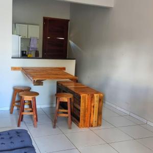 a kitchen with wooden tables and stools in a room at Casa 03 in Parnaíba