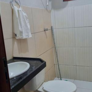 a bathroom with a white sink and a toilet at Casa 03 in Parnaíba