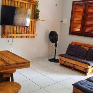 a living room with a couch and a flat screen tv at Casa 03 in Parnaíba