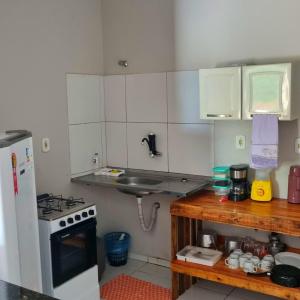 a small kitchen with a sink and a stove at Casa 03 in Parnaíba +8 photos