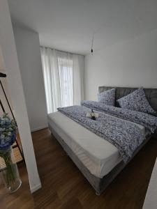 a bedroom with a large bed with blue sheets and pillows at Stilvolle Neubauwohnung mit Balkon&WLAN in Hannover