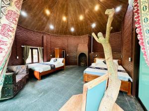 a bedroom with two beds and a tree in it at Ba be farmstay in Ba Be