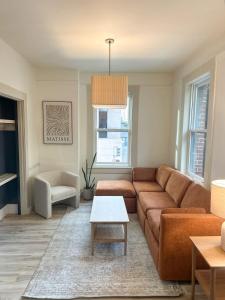 Una sala de estar con un sofá marrón y una mesa. en Union Square city views, en San Francisco