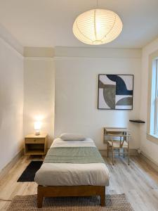 1 dormitorio con 1 cama, 1 mesa y 1 lámpara en Nice large size room in Union Square, en San Francisco