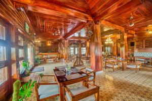a living room with wooden walls and tables and chairs at Vintage Trails By Ilara in Alūr