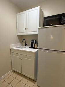 a kitchen with a sink and a microwave and a refrigerator at Aurora Inn in Kingston