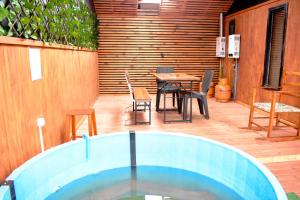 - un bain à remous sur une terrasse avec une table et des chaises dans l'établissement Cabaña Parcela Nativo, à Los Álamos