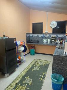 a kitchen with a black refrigerator and a counter at Mysara Homestay Batu Gajah Tanah Merah in Tanah Merah