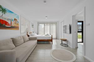 a white living room with a couch and a bed at Sun and Sea in Berrara