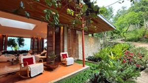 a house with a deck with chairs and a living room at Chalet, Free Suzuki Jimny 4x4, Port pick-up and drop-off service, and Unlimited Massage Chair Use in Maria
