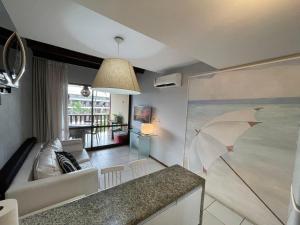 a living room with a couch and an umbrella on the wall at Nannai Residence - Flat de luxo in Porto De Galinhas