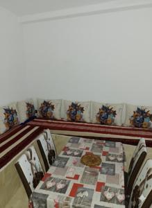 a table and chairs with a quilt on it at شفشاون in Chefchaouene