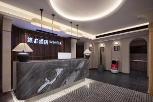 a lobby with a reception desk in a building at Changsha WeiYi Hotel in Changsha