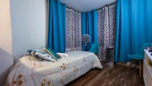 a bedroom with a bed with blue drapes at Metro Santa Ana 2 dormitorios wifi check in tardío in Santiago