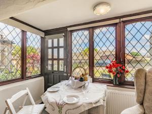 une salle à manger avec une table et des fenêtres dans l'établissement Halcyon Cottage, à Deepcar