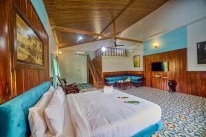 a bedroom with a large bed and a blue couch at Vintage Trails By Ilara in Alūr