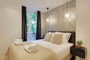 パリにあるPick A Flat's in Champs Elysees - Rue Percierのベッドルーム1室(ベッド1台、タオル2枚付)