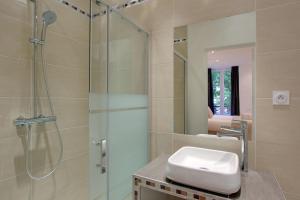 a bathroom with a glass shower and a sink at Pick A Flat's in Champs Elysees - Rue Percier in Paris