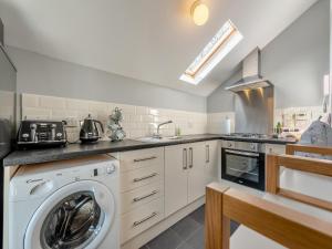 a kitchen with a washing machine and a sink at West Llwyn - Uk41757 in Rhyd Owen