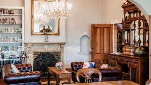 a living room with a chandelier and a fireplace at The Dragonfly Inn in Launceston
