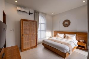 a bedroom with a large bed and a window at Byjexa Villa by Betterplace in Uluwatu +75 photos
