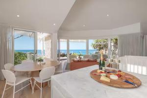 a kitchen with a table and a dining room with the ocean at Seaviews at Sunshine Beach 4BR, Pool in Sunshine Beach