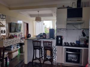 a kitchen with two chairs and a counter with a stove at Apartamento Classic in Belém +18 photos