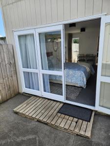 a sliding glass door with a bed in a bedroom at Cosy Studio Unit on Longview in New Plymouth