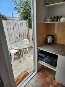 a small kitchen with a table and a glass door at Cosy Studio Unit on Longview in New Plymouth