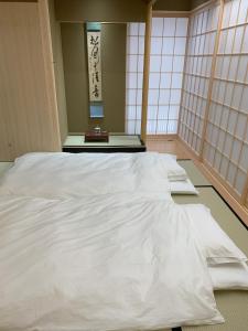 ein großes weißes Bett in einem Zimmer mit Fenstern in der Unterkunft Kaga - House - Vacation STAY 17904 in Kaga