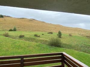 a view of a grassy hill with a wooden fence at Appartement cosy pour 4 pers. avec balcon - FR-1-814-155 in Chastreix