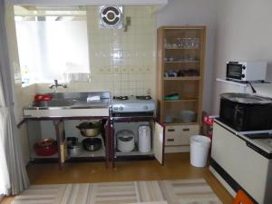 a small kitchen with a sink and a stove at Sun Terrace Hakone in Hakone