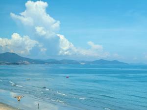 een uitzicht op een strand met mensen in het water bij Cloud Coast Hotel in Kang-k'ou