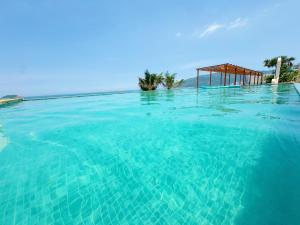 een groot zwembad met blauw water en een prieel bij Cloud Coast Hotel in Kang-k'ou