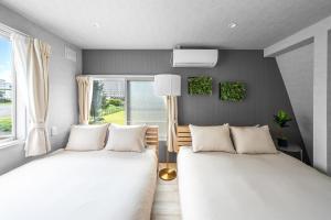 富良野市にあるThe ARBANOのベッド2台と窓のある寝室