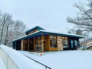 a building with snow on the ground in front of it at scène セヌ in Daisen