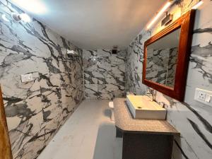 un baño con lavabo y espejo en Serendipity Desert Dunes Luxury Resort By Royal Empire, en Jaisalmer 48 fotos más