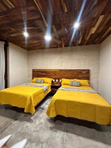 ChanoLuxury Dream Village in Palmarito Puerto Escondido的配有黄色床罩的客房内的两张床 更多18张照片