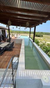 ChanoLuxury Dream Village in Palmarito Puerto Escondido的带有木质甲板和木质屋顶的游泳池