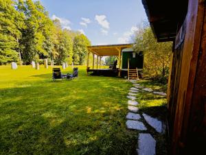 a house with a tent and chairs in a yard at Maringotka Slaměnka u menhirového kruhu - U Slaměnky in Hněvětice