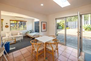 a living room with a table and chairs at The Onetangi Gathering - Beach, Family, Connection in Waiheke Island +21 photos