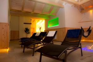 eine Gruppe Stühle in einem Zimmer mit grünem Bildschirm in der Unterkunft Alpengasthof Norbertshöhe Superior in Nauders