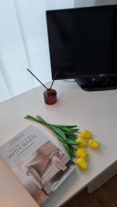 a table with a magazine and some flowers and fruit at Huestay Gumdan in Samgong