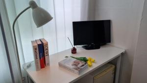 a desk with a television and books and a lamp at Huestay Gumdan in Incheon