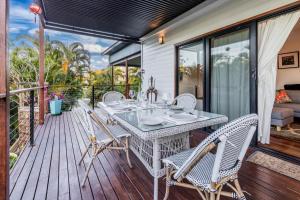 a patio with a table and chairs on a deck at Shambala Pet Friendly Apartments Agnes Water in Agnes Water