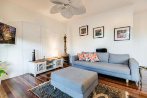 een woonkamer met een blauwe bank en een tafel bij Shambala Pet Friendly Apartments Agnes Water in Agnes Water