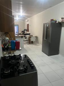 y cocina con fogones y nevera. en Casa grande Com 2 quartos e 2 suítes, en Castanhal